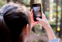 Smartphone Ownership, Internet Use and Digital Divides Woman Using Her Smartphone While Taking the Picture the Forest