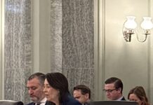 The Future of TV Ownership Rules: On Cruz Control? Sen. Ted Cruz (R-Tex.) checks his smartphone as Ranking Member Maria Cantwell (R-Wash.) delivered her opening statement in a February 10, 2026 hearing on the national TV ownership reach limits.